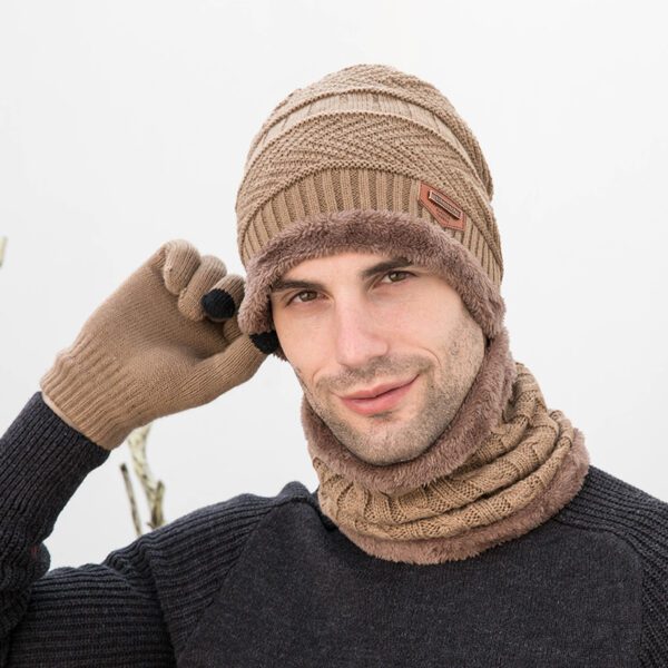 A man wearing a hat, scarf and gloves.