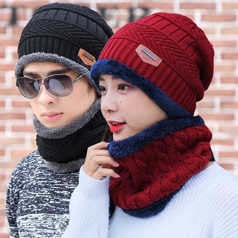 A man and woman wearing hats and scarves.