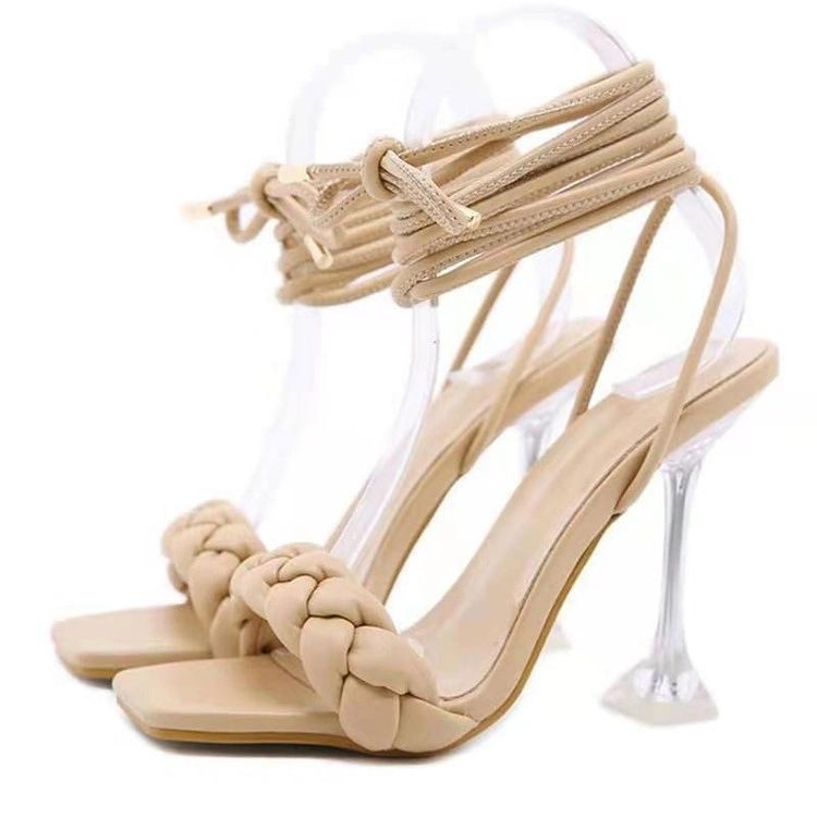 A pair of beige sandals with clear heels.